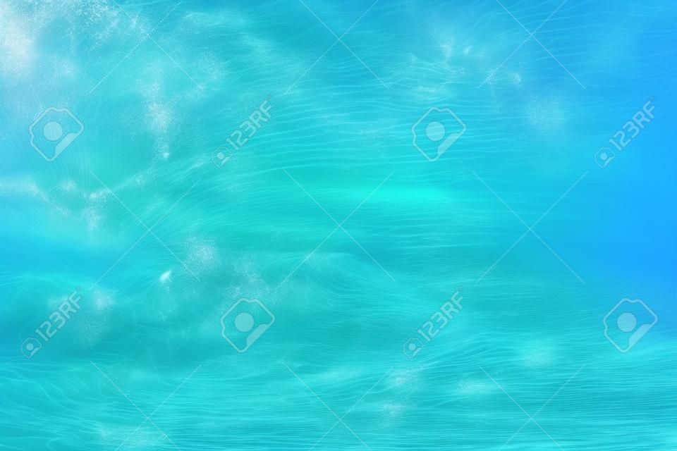 海洋极端波浪在热带海滩上的水下照片，水面上有浪花泡沫波纹，气泡图案为浅蓝色，背景清晰，海面纹理清晰。