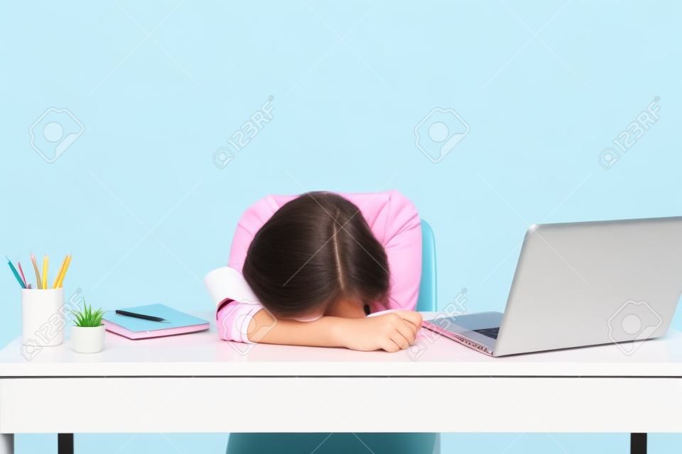 Young Disappointed Tired woman laid her head down on the table sit, work at white desk with contemporary pc laptop isolated on pastel pink background. Achievement business career concept. Copy space
