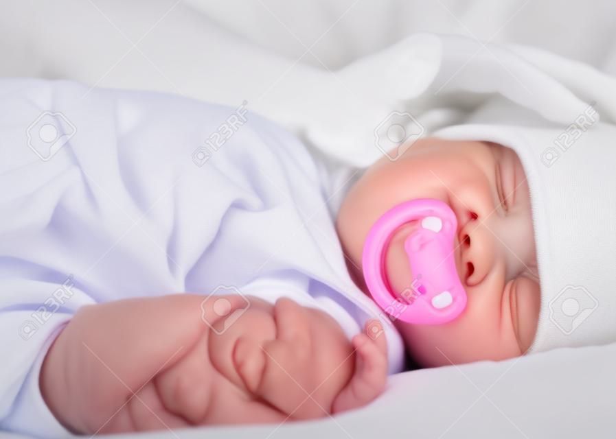 Emzik beyaz Baldakenli üzerinde uyku ile onun sevimli bebek kız sevecen anne eli