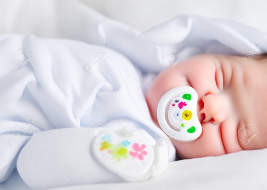 Emzik beyaz Baldakenli üzerinde uyku ile onun sevimli bebek kız sevecen anne eli