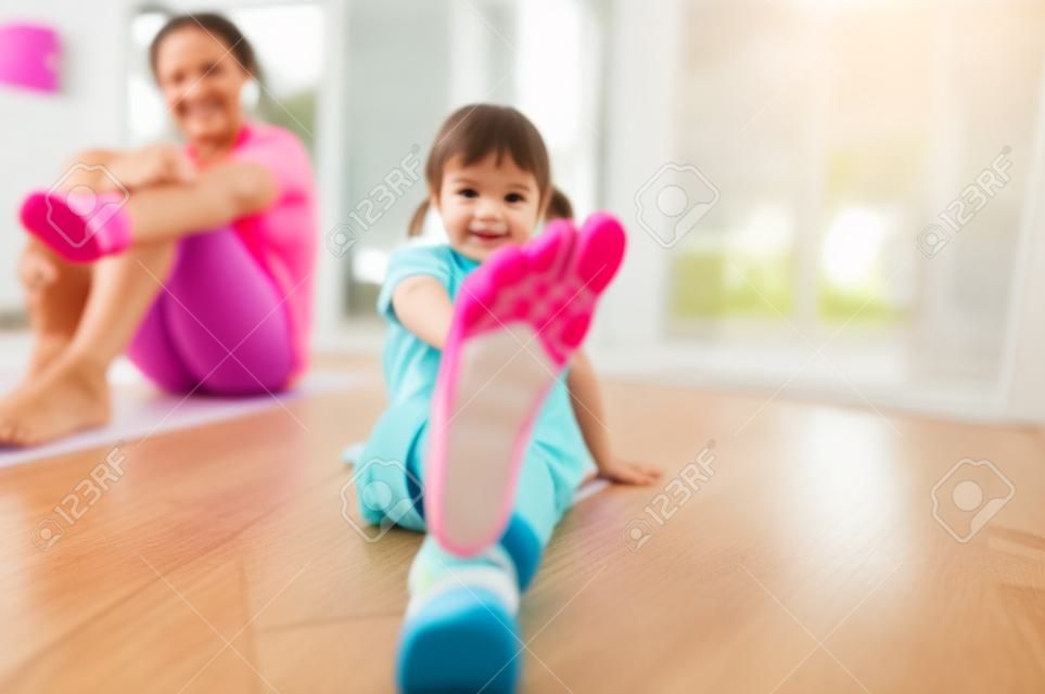 Concentreer je op de voet van een klein meisje dat traint met haar moeder thuis.