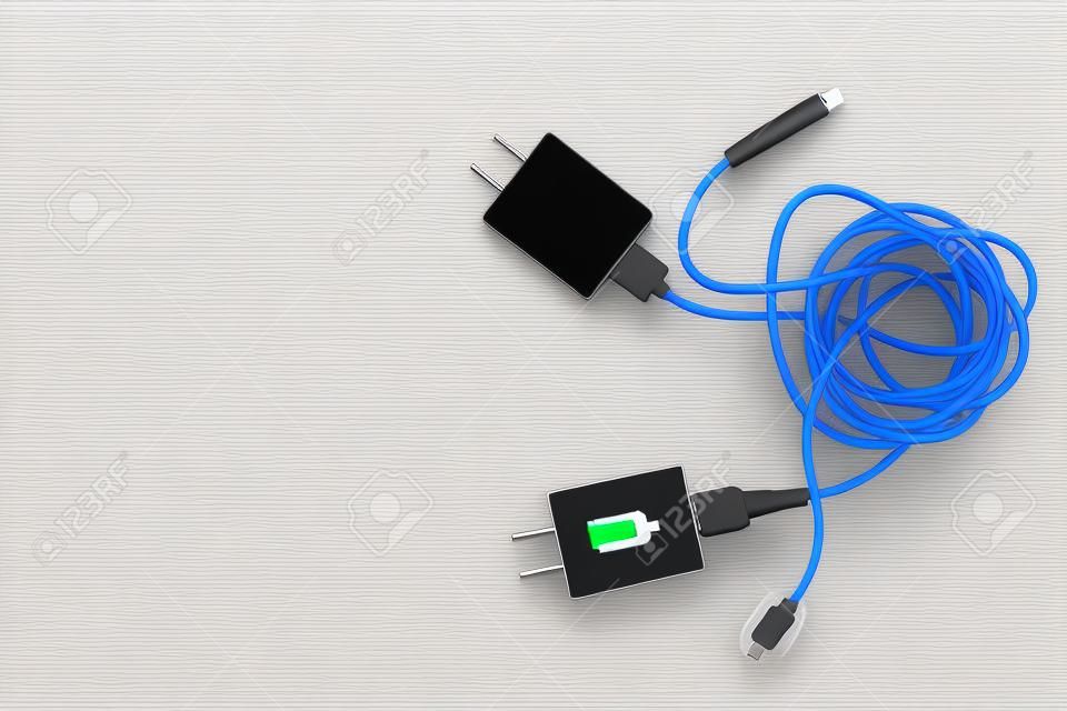 Kabelsalat von zwei Smartphone-Ladesteckern, die mit weißen und schwarzen USB-Kabeln verbunden sind