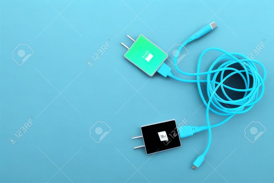 Kabelsalat von zwei Smartphone-Ladesteckern, die mit weißen und schwarzen USB-Kabeln verbunden sind