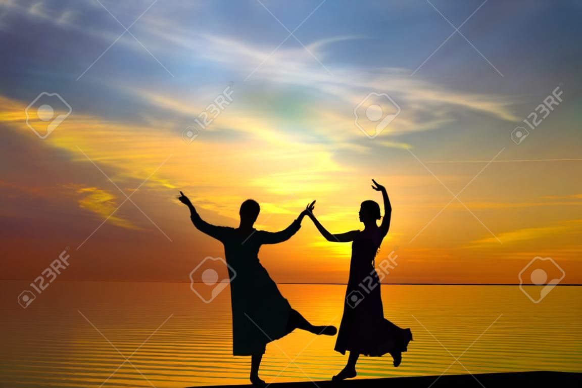 Two silhouette dancers in front of the sunset