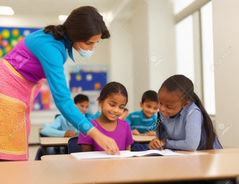 Teacher helping school kids in classroom
