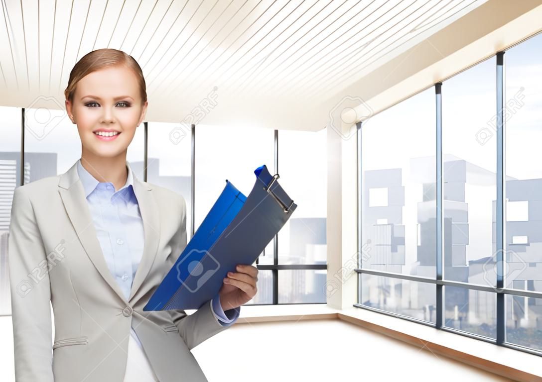biznes, nieruchomości, bankowości i koncepcja ludzie - uśmiechnięte businesswoman z folderu i klucze na sali biurowej lub nowym mieszkaniu tle