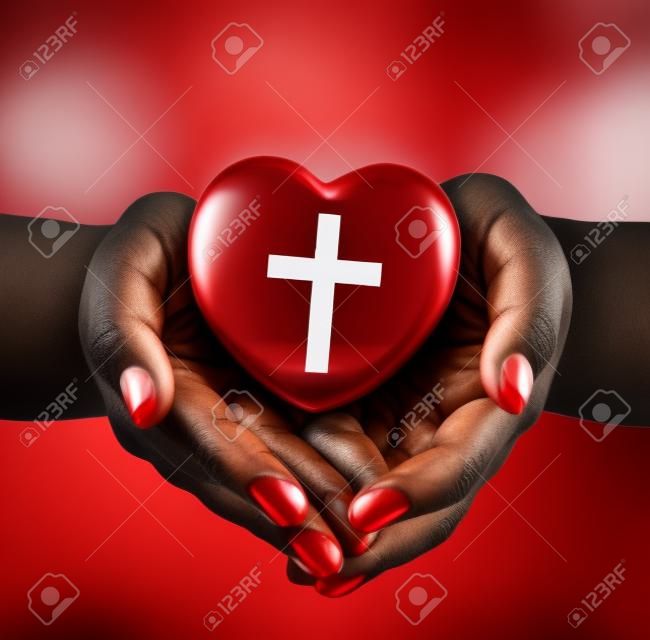 religión, cristianismo y el concepto de la caridad - afroamericano manos femeninas celebración de corazón rojo con el símbolo de la cruz cristiana