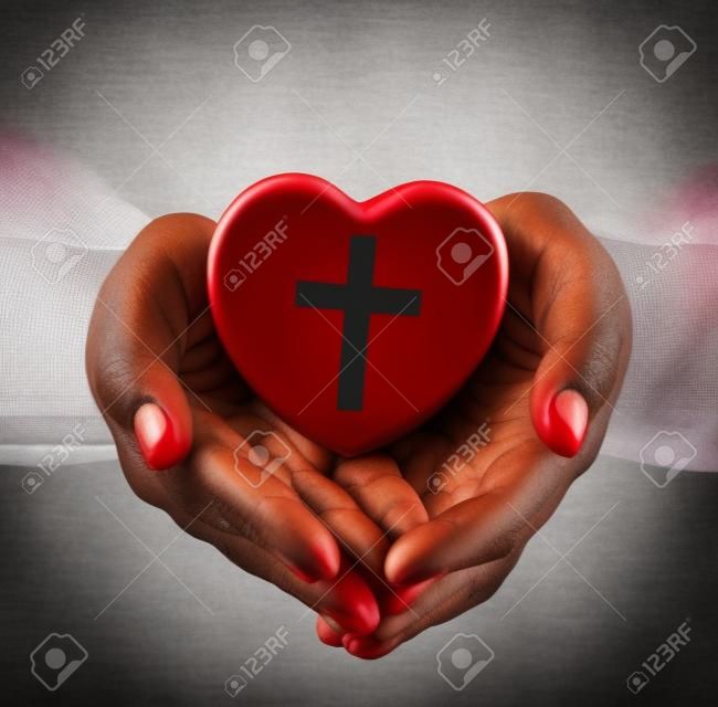 religione, cristianesimo e il concetto di carità - africano mani femminili americane che tiene cuore rosso con christian simbolo della croce