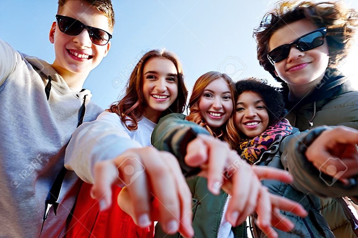 emberek, szabadidő, gesztus és a tizenéves fogalma - csoport boldog tizenéves barátok mutogatnak a városi utca