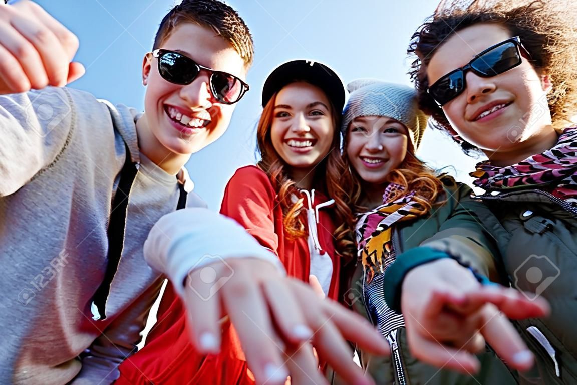 la gente, el ocio, el gesto y el concepto de adolescente - grupo de amigos adolescentes felices que señalan los dedos en la calle de la ciudad