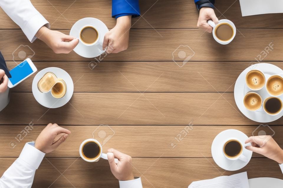 business, people and team work concept - close up of creative team meeting and drinking coffee during lunch in office