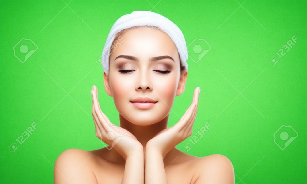 beleza, pessoas, cuidados com a pele e conceito de saúde - jovem mulher rosto e mãos sobre fundo natural verde