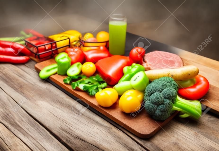 balanced diet, cooking, culinary and food concept - close up of vegetables, fruit and meat on wooden table