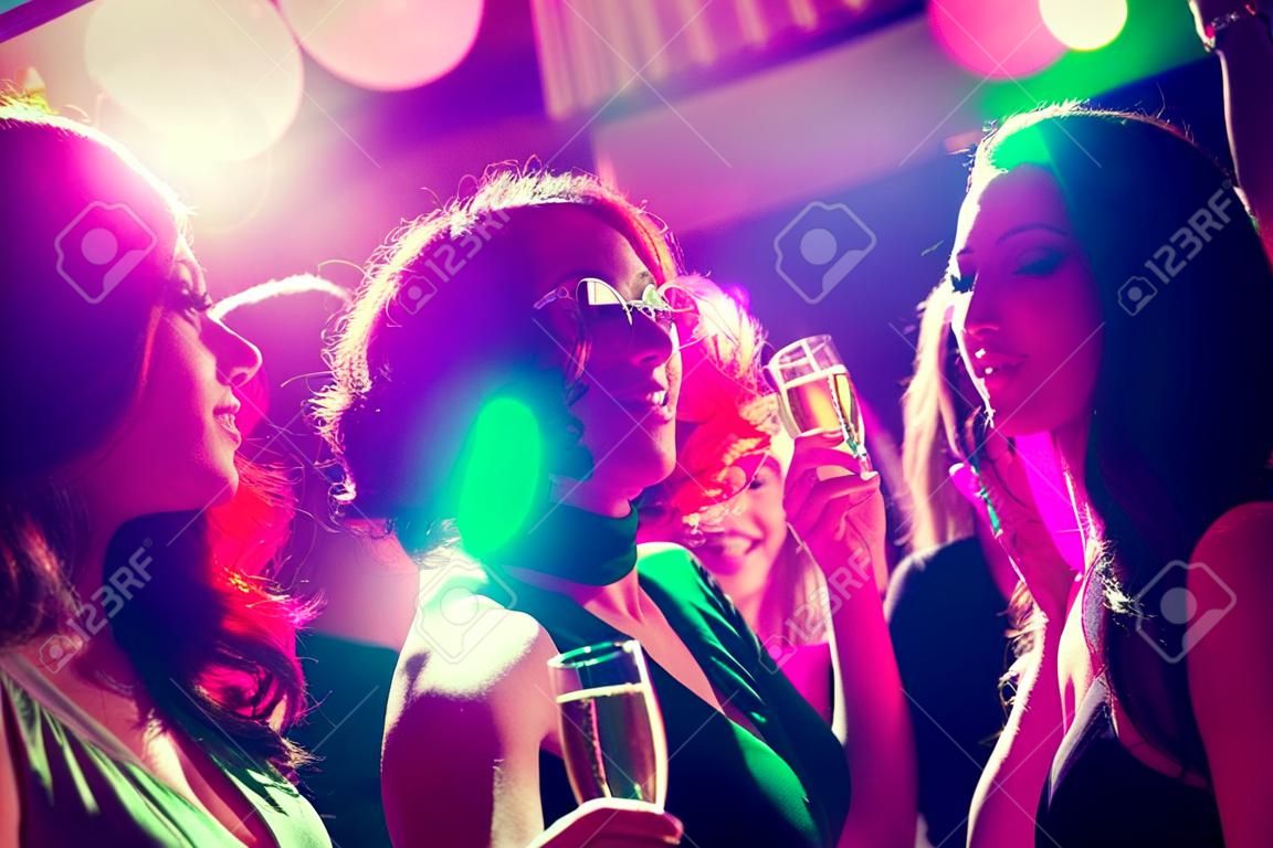 派对假日庆祝夜生活和人的概念-微笑的朋友与香槟酒杯在俱乐部