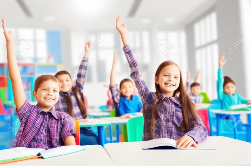 교육, 초등 학교, 학습 및 사람들이 개념 - 학교 아이들과 교실에 앉아 손을 올리는 노트북의 그룹
