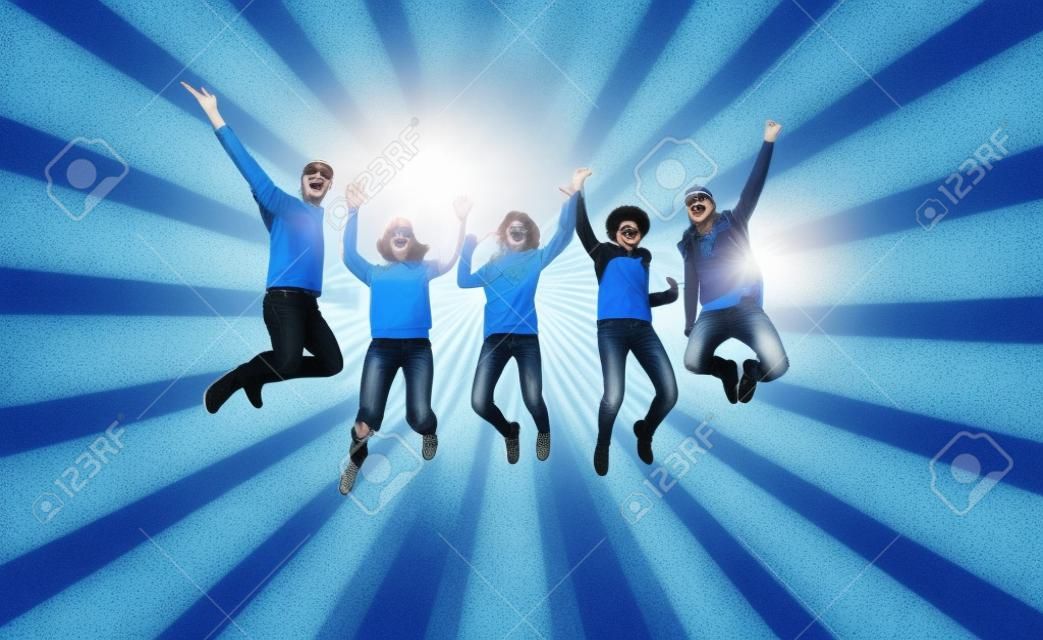 las personas, la libertad, la felicidad y el concepto de adolescentes - grupo de amigos felices con gafas de sol salto de altura sobre fondo azul los rayos de ráfaga