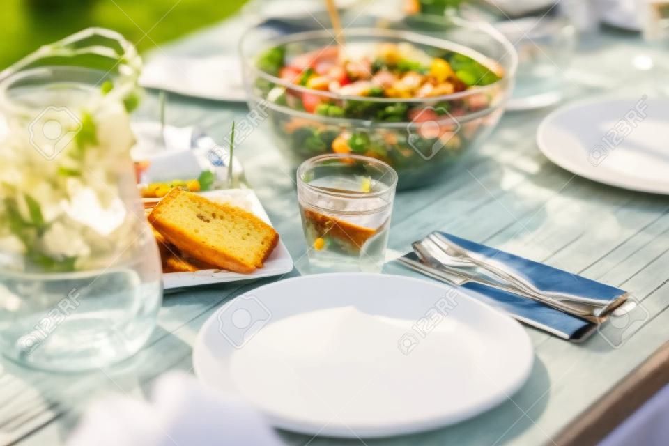 стол с едой на обед в летнем саду партии