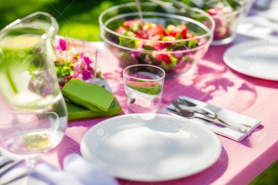 стол с едой на обед в летнем саду партии