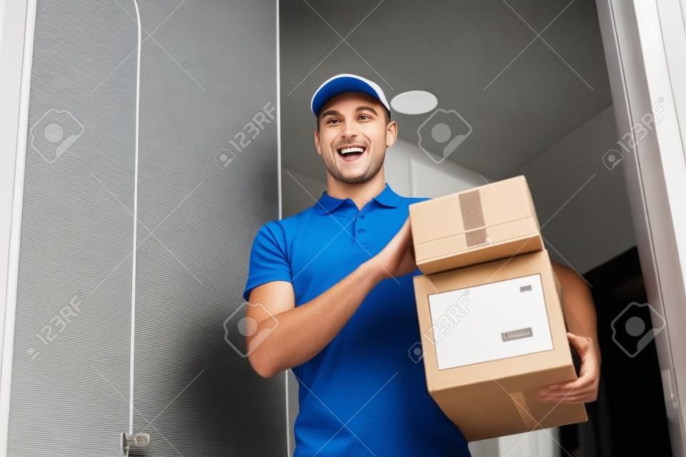 Uomo di consegna con scatole di pacchetto alla porta del cliente