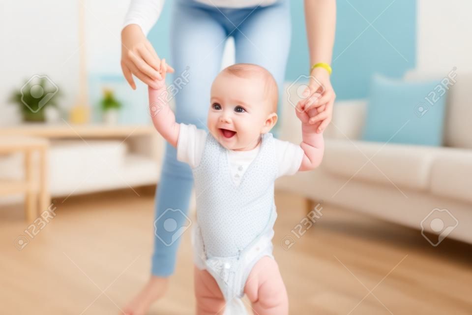 gelukkig baby leren lopen met moeder hulp