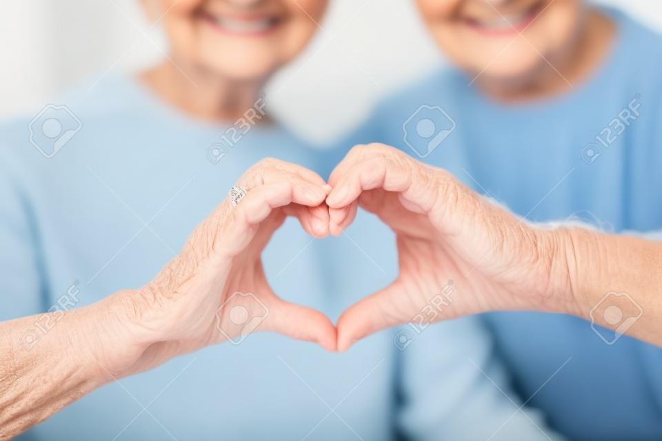 Nahaufnahme von senior Paar zeigt Hand Herzschild