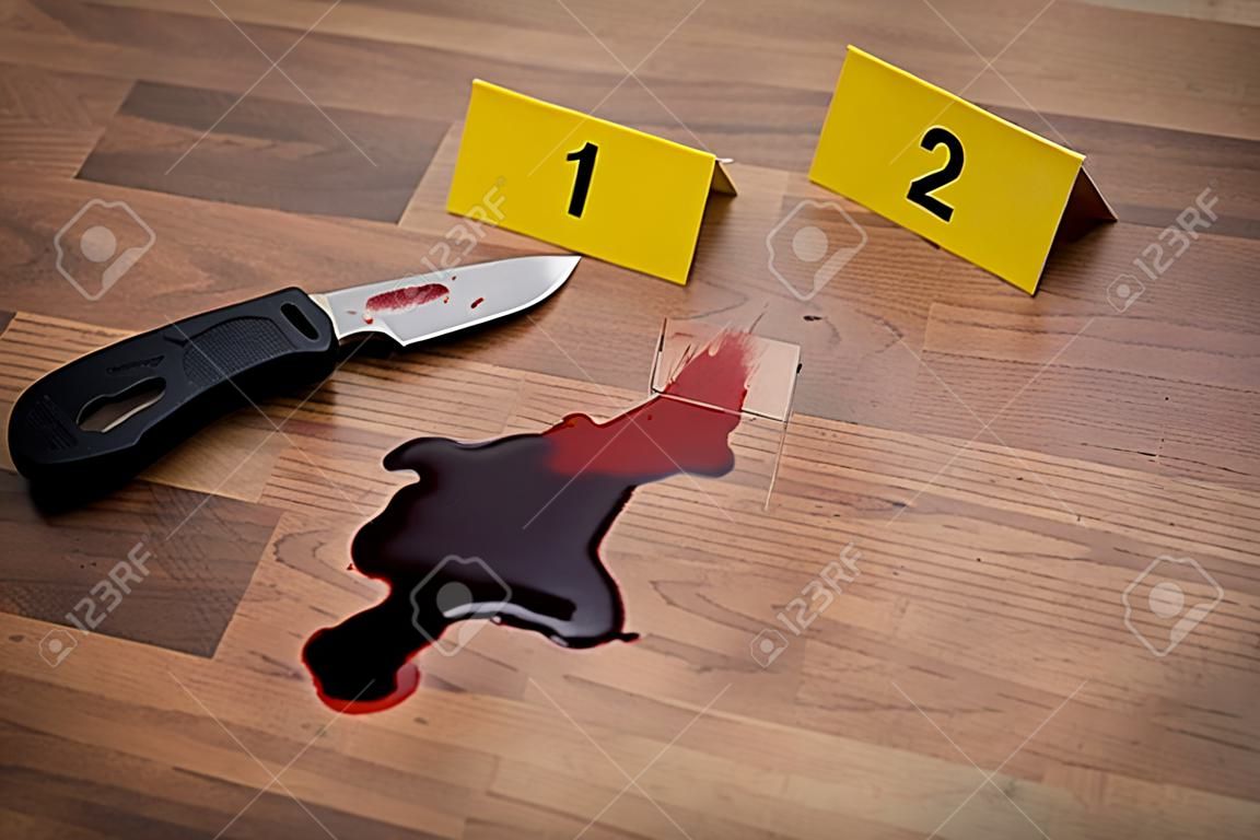 犯罪現場で血液中のナイフと証拠マーカー