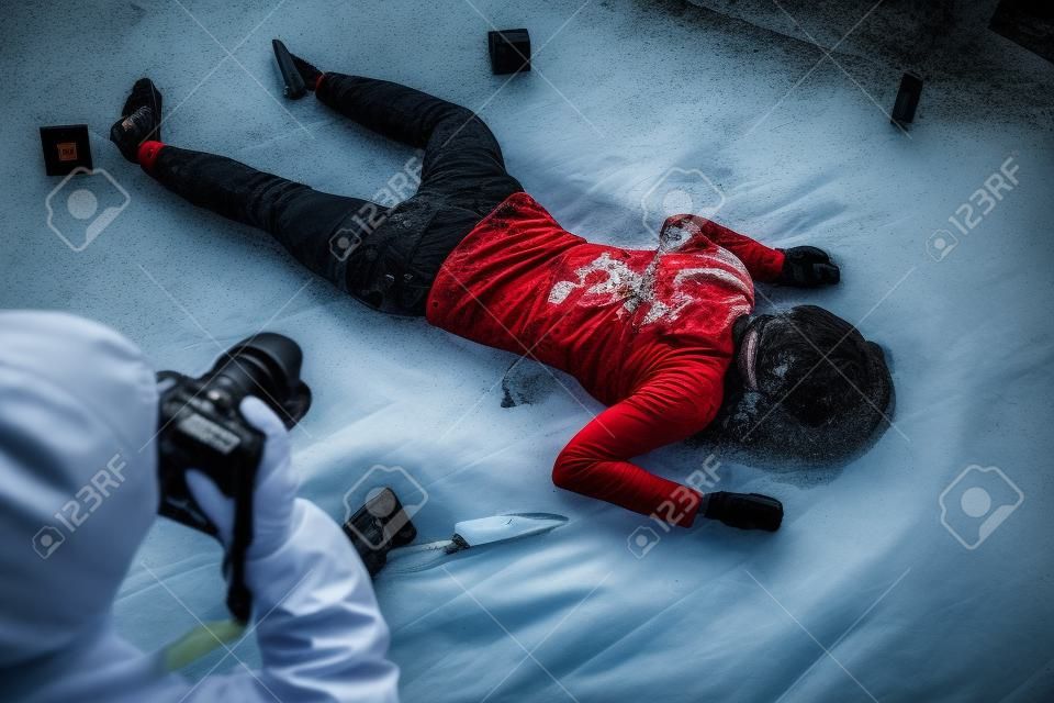 criminalista fotografiando cadáver en la escena del crimen