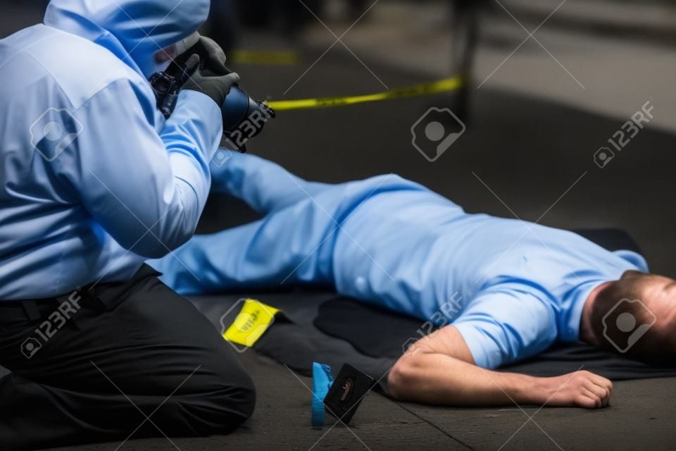 criminalist photographing dead body at crime scene