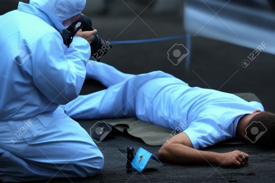 criminalista que fotografa o corpo morto na cena do crime