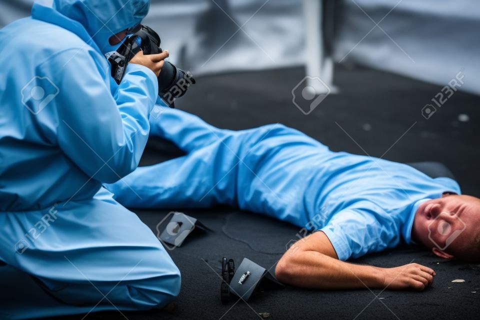 criminalista que fotografa o corpo morto na cena do crime