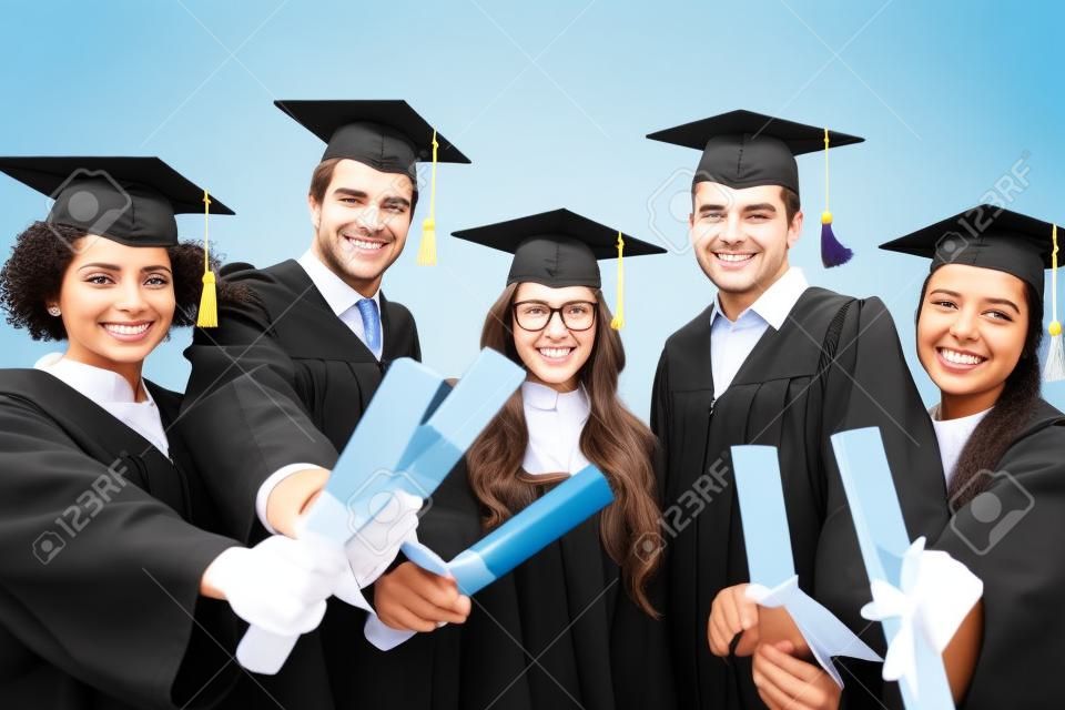 glückliche Schüler in Mörteltafeln mit Diplomen