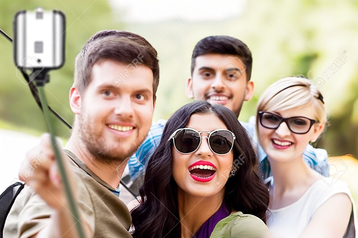 amici che scattano foto da selfie stick in estate