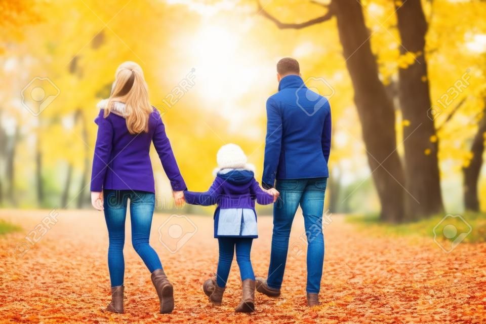 concept de famille, de saison et de personnes - mère heureuse, père et petite fille marchant au parc d'automne