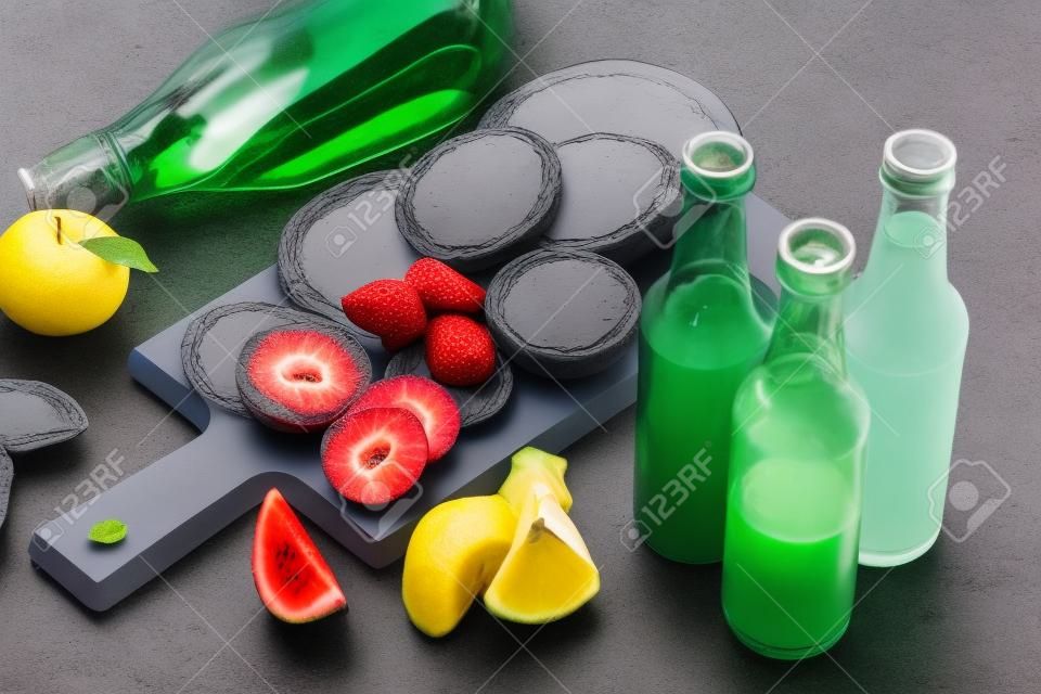 Bottiglie di vetro di succo di frutta sul piano del tavolo in ardesia