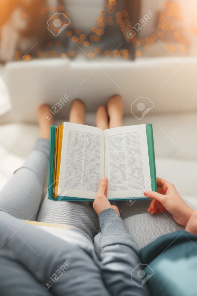 close up of couple reading book at home