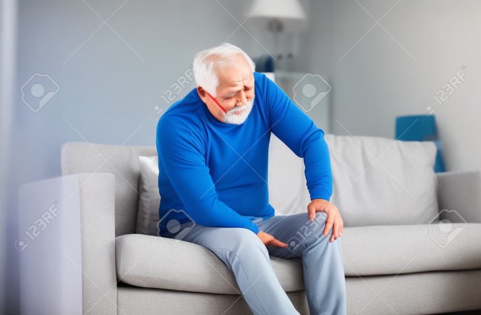 uomo anziano che soffre di dolore al ginocchio a casa