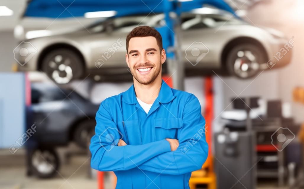 happy auto mechanic man or smith at car workshop