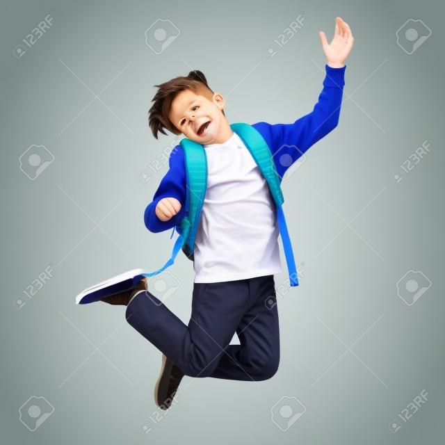 happy smiling student boy with school bag jumping