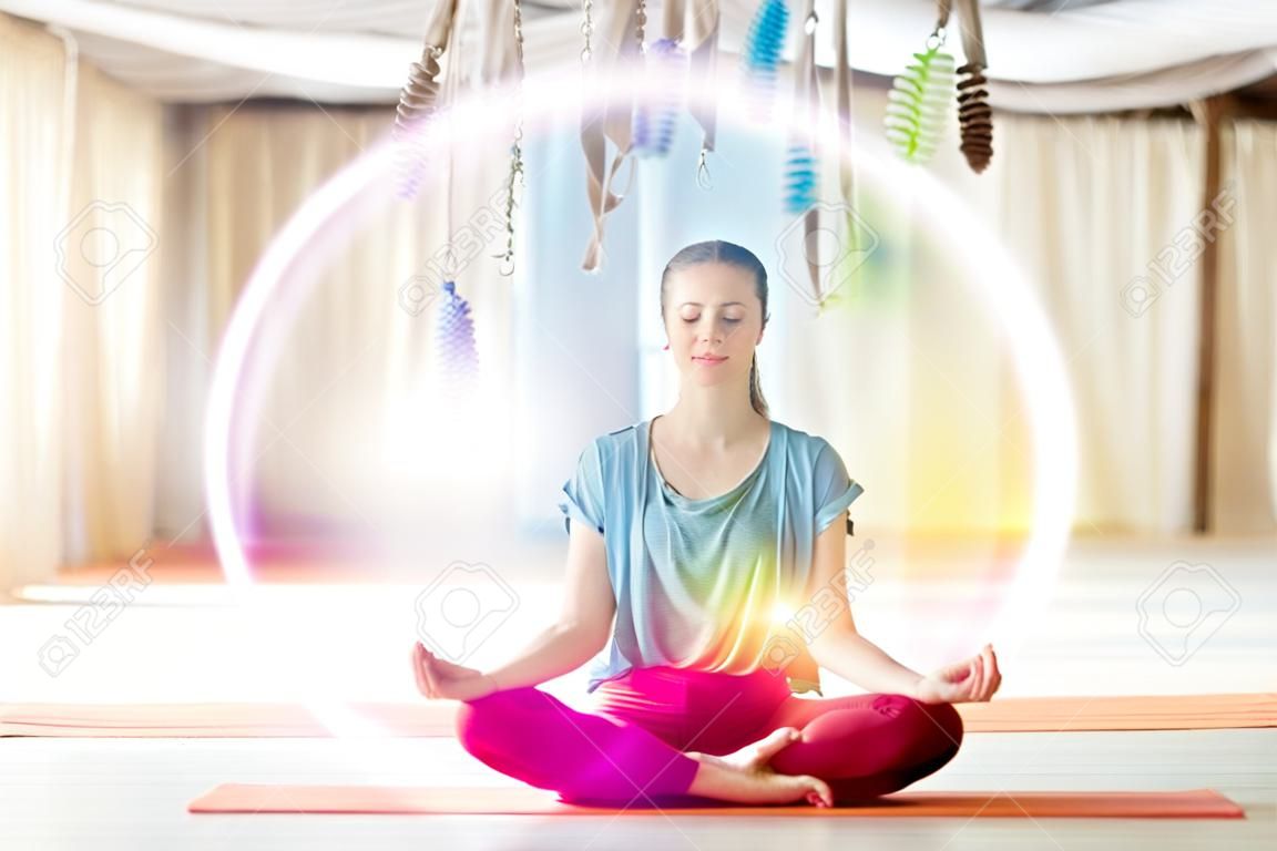 Donna che medita nella posa del loto allo studio di yoga