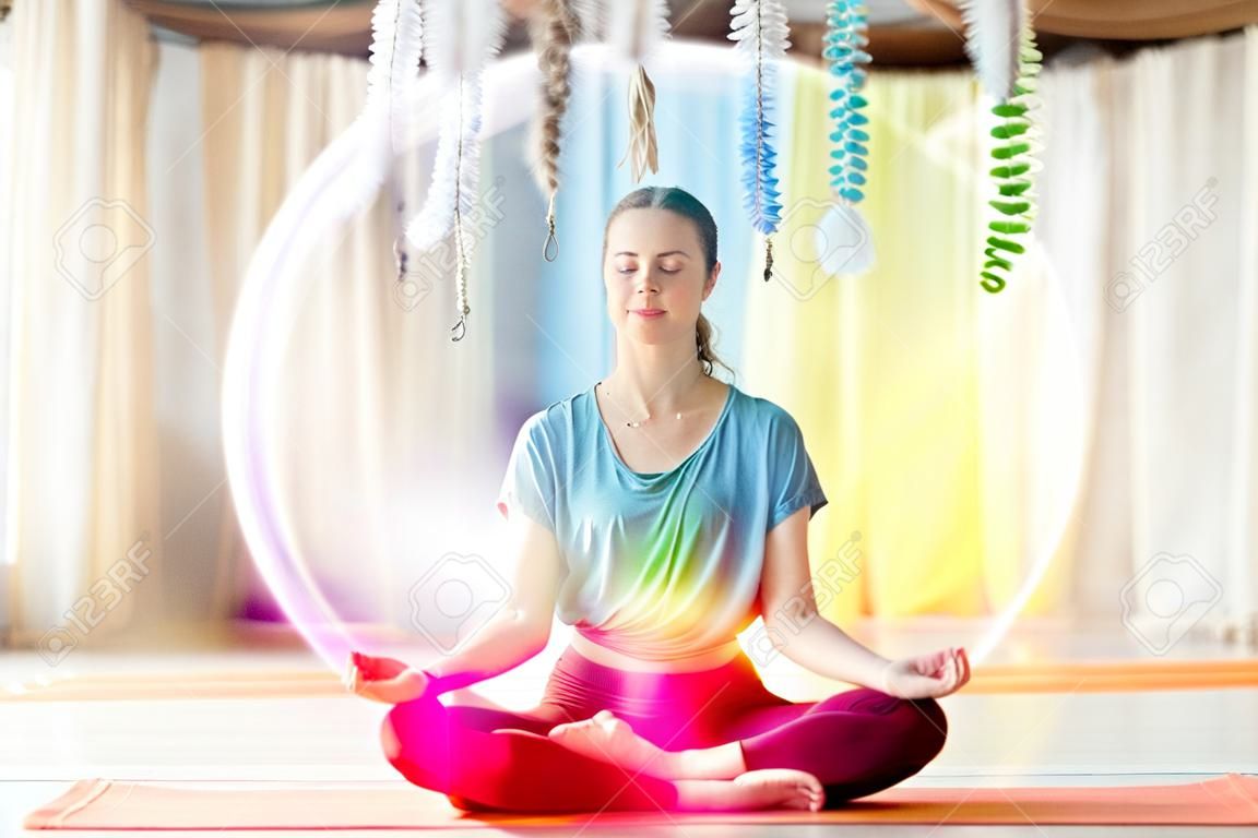 Donna che medita nella posa del loto allo studio di yoga