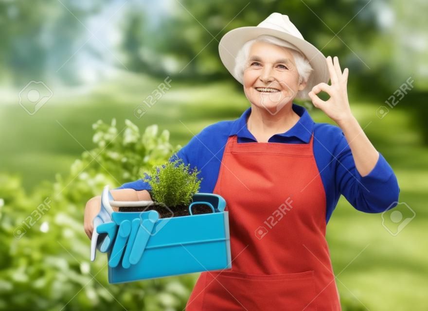 anciana con herramientas de jardín en caja mostrando ok