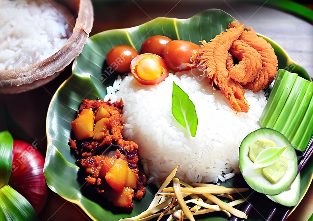 Nasi lemak is een gerecht dat rijst bevat die geurig is gemaakt met kokoscrème en pandanbladeren.