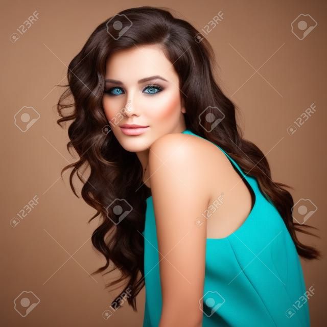 Bella modelo morena con el pelo largo rizado de color marrón. Pretty modelo posa en el estudio.