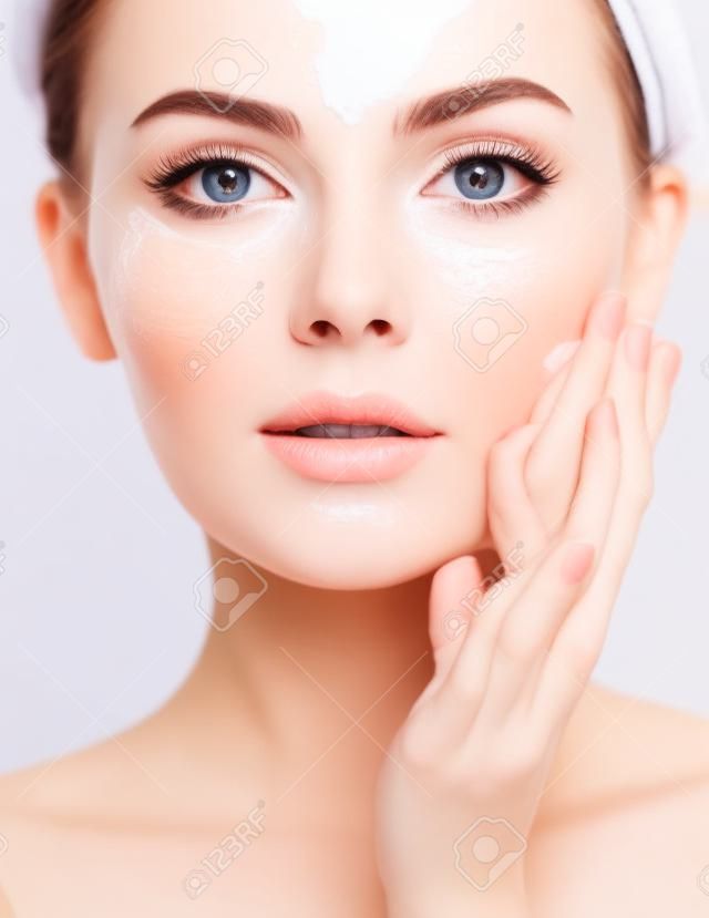 Beautiful face of young caucasian woman with perfect healthy skin, isolated.   Pretty white model caring of face.  Skin care concept. Girl moistens her face.  Woman with soap foam street.
