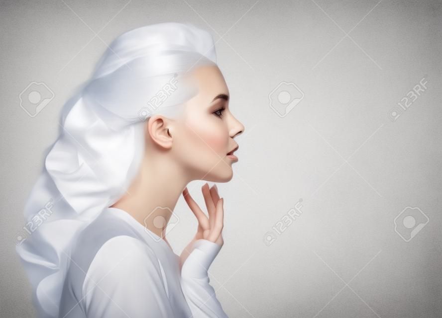 Portret pięknej kobiety dotykającej palcami szyi - na białym tle