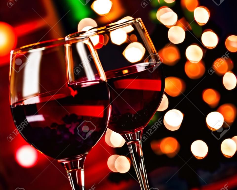 Noel karşı iki kırmızı şarap cam dekorasyon arka plan, yılbaşı atmosferini ışıkları