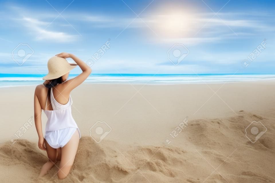 Счастливый молодая красивая азиатская женщина отдыхает на песок на тропический пляж