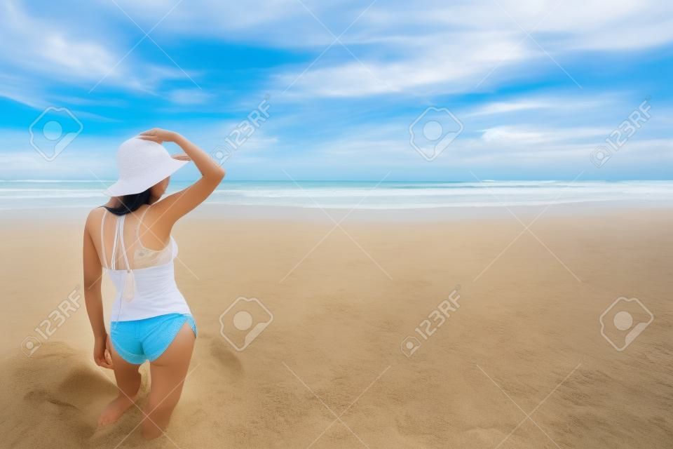 Счастливый молодая красивая азиатская женщина отдыхает на песок на тропический пляж