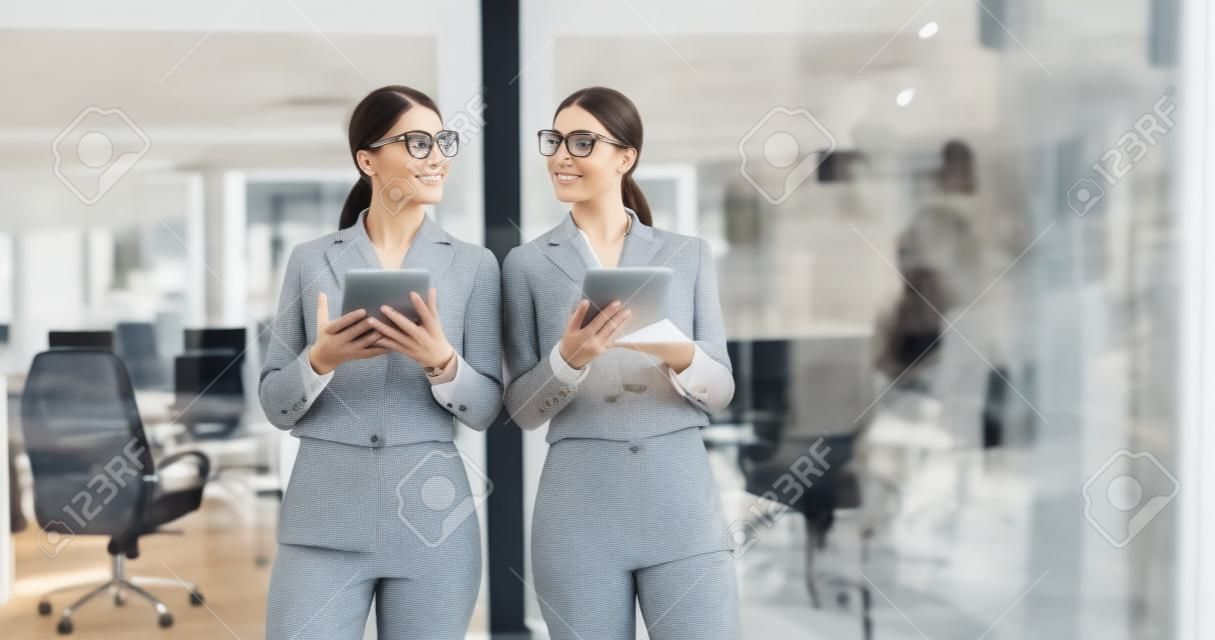 Pretty Businesswoman Using Tablet In front of Office Interior
