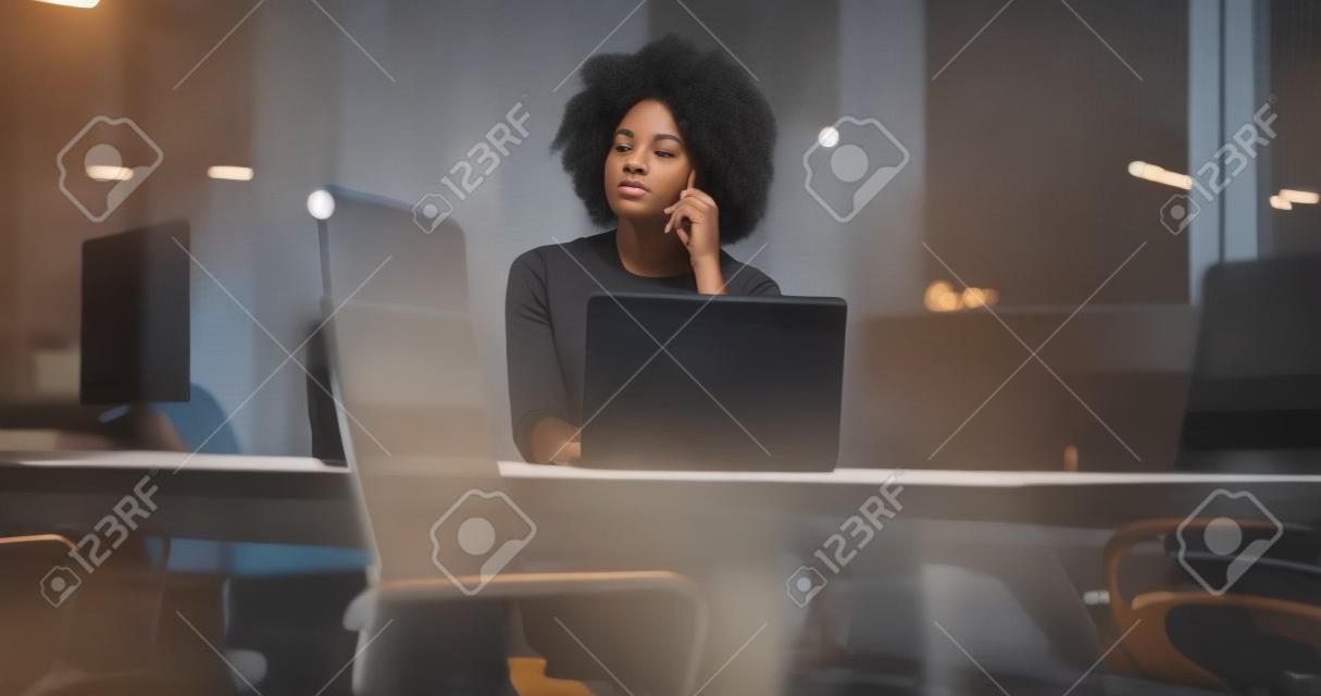 jeune africaine agent féminin américain freelancer travaillant en utilisant un ordinateur portable dans l & # 39 ; espace de la nuit coworking
